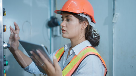 Professional factory manager checking and controlling machine at factoryの写真素材