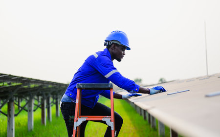Maintenance engineer installing solar panels on solar cell farmの写真素材