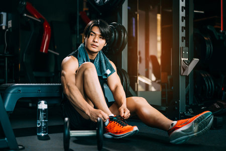 Healthy young man relaxing after exercises workout in fitness gymの写真素材