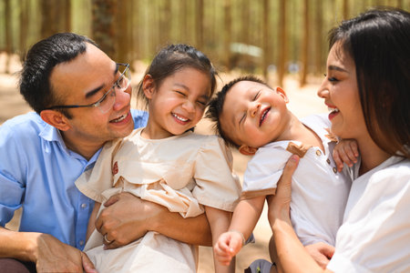 Smiling portrait of happy family travel together in park on weekendの写真素材