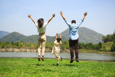Happy family relaxing and playing outdoor together in park on weekendの写真素材