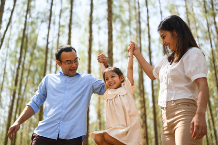 Happy family having fun with summer trip in park together on weekendの写真素材