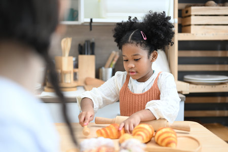 Happy children girls playing with flour and laugh in kitchenの写真素材