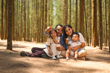 Happy parents and children looking at camera with smile at parkの写真素材