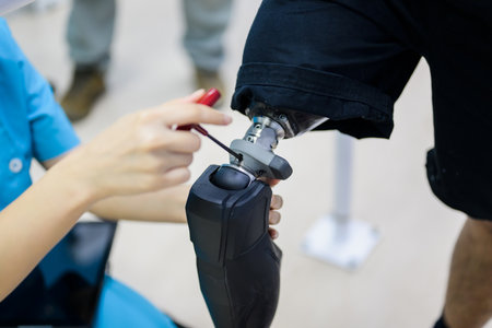 Female physiotherapist adjusting prosthetic leg of patient in hospital