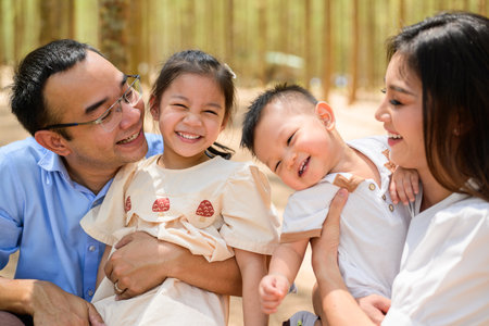Happy family having fun with activities together in park on weekendの写真素材