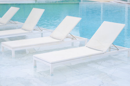 Chairs in swimming pool at luxury hotel, Summer vacation at poolside