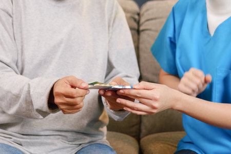Caregiver nurse taking care of elderly grandfather at home