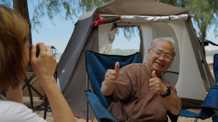 Happy Asian family with barbecue party at camping beach togetherの写真素材
