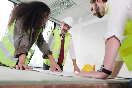 Construction engineers team using blueprint of project plan