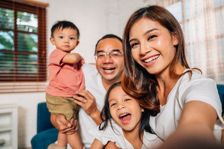 Happy family father mother and children taking selfie photosの写真素材