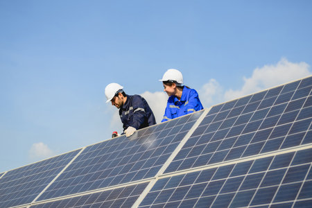 Technicians workers installing solar panels at solar cell farmの写真素材
