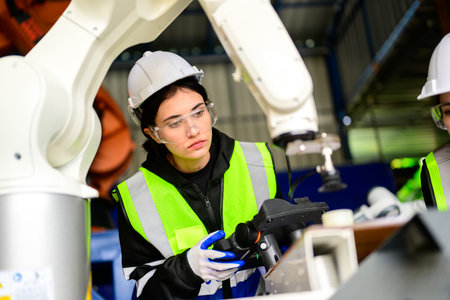 Industrial engineers checking and controlling machine at factoryの写真素材