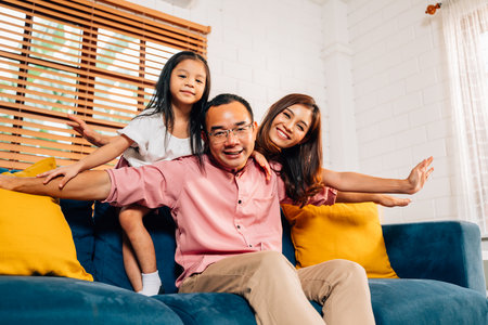 Cheerful family playing together in living room at homeの写真素材