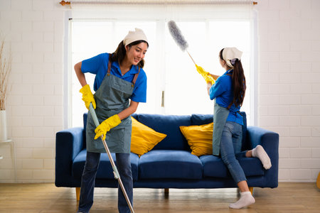 Couple of housekeeping staff cleaning house, Housekeeping and cleaning service, People doing housework at homeの写真素材