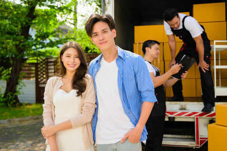 Man and woman accepting and holding delivery parcel boxes from deliveryman at home, Delivery service at homeの写真素材