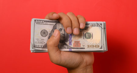 Hundred dollar bills on red background, Banknotes for money saving, Cash money dollars, Business investment and income, Global financial crisis, Earning and saving money conceptの写真素材