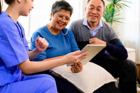 Doctor or nurse caregiver with senior patient at home or nursing home, Female doctor holding tablet visiting patient in hospital, Doctor caregiver in uniform talking with senior peopleの写真素材