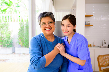 Doctor or nurse caregiver with senior patient at home or nursing home, Female doctor visiting patient in hospital, Doctor caregiver wearing uniform comforting and supporting patientの写真素材