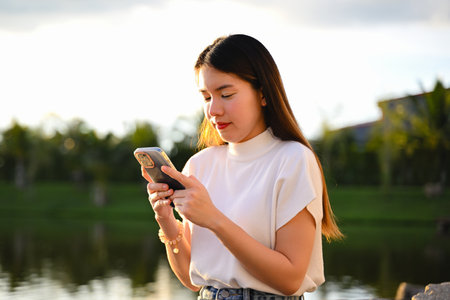 A woman is using a smart phone for various daily activities. The photo is of high quality.の写真素材