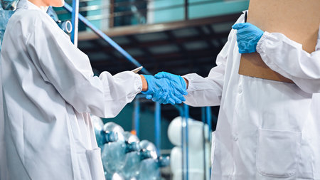 Bottling factory worker inspecting quality of water bottles before shipment. Reverse osmosis system...