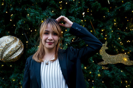 Blond hair woman scratch her head while standing in fron of Christmas tree with light decoration.