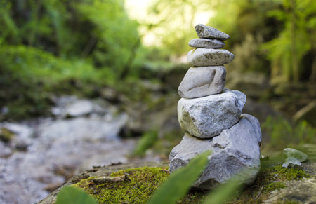 Stack of pebble stones by a stream in a forest