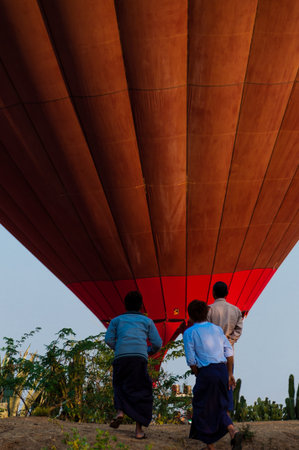 Men standing in front of hot air balloon in Bagan myanmar Burmaのeditorial素材