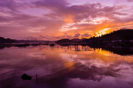 Pretty Pink orange Sky cloudscape over an island with reflection at Sunset on the Island of Coron, Palawan, Philippinesの写真素材