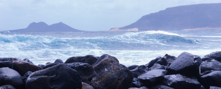 Black rock stone coast in front of rough windy sea with waves on cape verde island