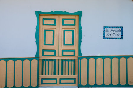 Yellow turquoise wooden door of a colonial house front in Salento, Colombia, South Americaの写真素材
