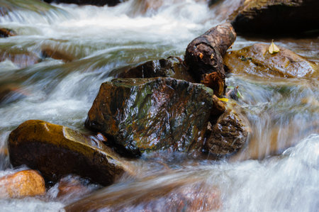 Closeup of water flowing around rocks with motion blur in Valle de Cocora, Cocora valley