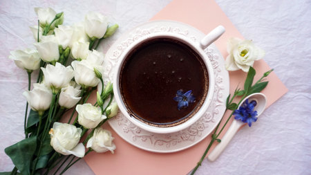 A cup of coffee and a bouquet of white rosesの写真素材