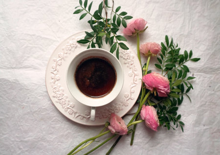 Vintage cup of coffee and pink ranunculus