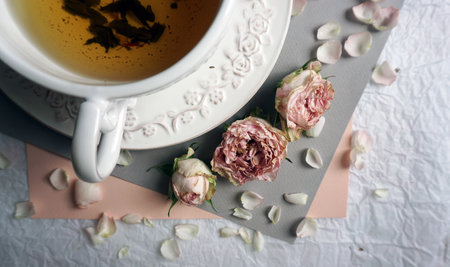 A cup of tea and dried roses in vintage styleの写真素材