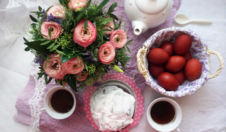 Easter basket, coffee for two and a bouquet of pink ranunculus