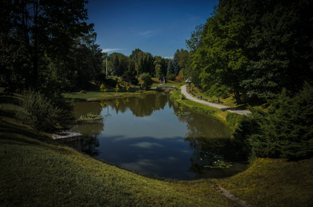 Beautiful landscape view of the pond in the park with a stone bridge and the clear sky