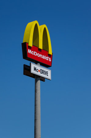 KATOWICE - JULY 13: McDonalds logo on blue sky background on July 13, 2011, Katowice, Poland.  McDonald's Corporation is the world's largest chain of hamburger fast food restaurants.のeditorial素材