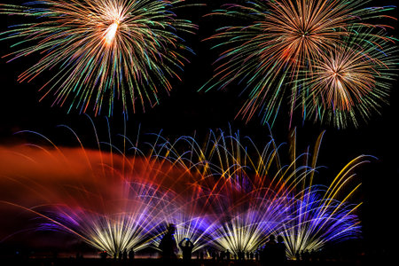 Colorful fireworks of various colors over night sky with spectatorsの写真素材