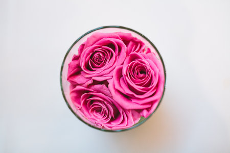 Top view of pink roses in glass table decorationの写真素材
