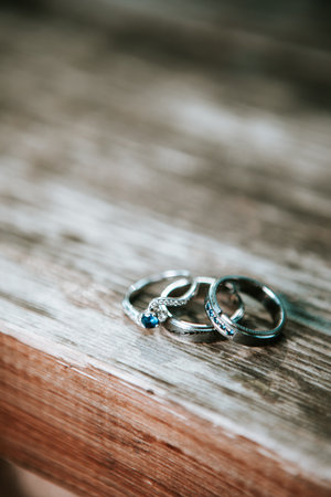 White gold wedding rings piled on vintage brown wood deskの写真素材