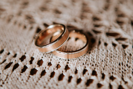 Gold wedding rings piled on vintage white lace close upの写真素材