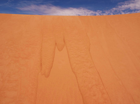 small avalanche of sand under a very blue skyの写真素材