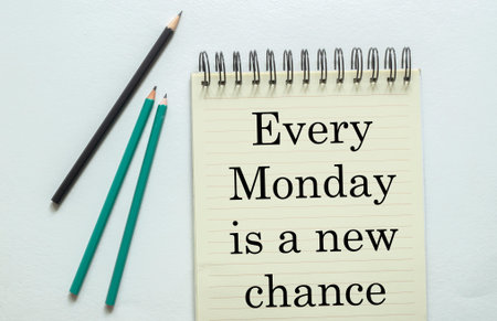 two green one black pencil with text Every Monday is a new chance in the notebook on the white...