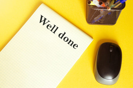 computer mouse, pens, felt-tip pens, notepad with text Well done