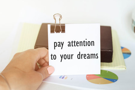 woman's hand holds a piece of paper with text