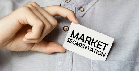 a man businessman in a blue shirt holds a card in a pocket with the text Market Segmentation in his handの写真素材