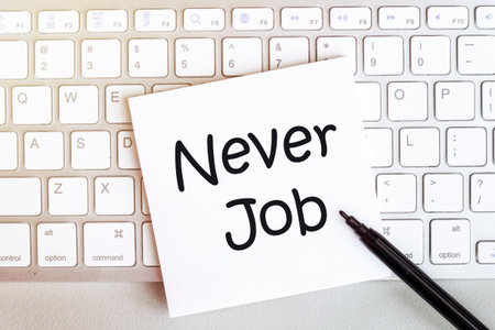 piece of paper with text Never Job on the keyboard on a white background with a black felt-tip penの写真素材