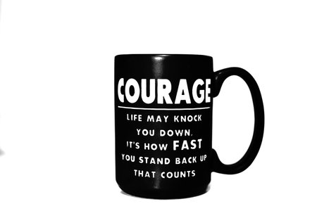 A black coffee mug with an inspirational quote written on it