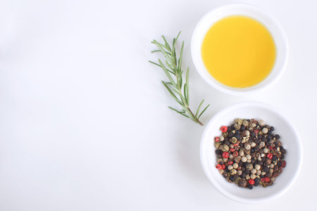 Olive oil porcelain plate Rosemary branch Pepper mix Cooking concept White background Top view Copy...